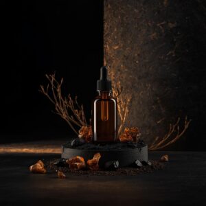 Frasco de vidro âmbar com o Óleo Senhor da Terra, posicionado entre raízes de vetiver e resinas de mirra, simbolizando a conexão com a terra e a cura ancestral.